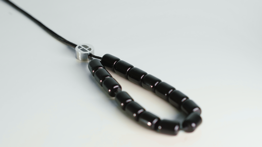 Accessoire antistress perles noires en résine et perle en acier inoxydable avec logo KOBOLOÏ, inspiré du komboloï. Crédit: Ragee M