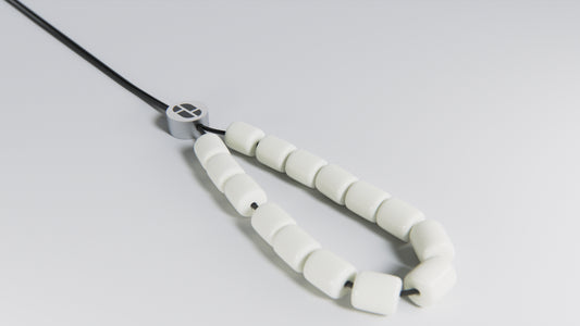Accessoire antistress perles blanches en résine et perle en acier inoxydable avec logo KOBOLOÏ. Crédit: Grégory Bergot